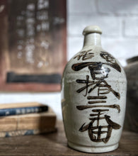 Load image into Gallery viewer, An early 20th Century, Vintage, stone Japanese Saki bottle with calligraphy in brown on cream.