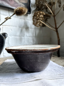 A vintage black glazed French Farmhouse style mixing bowl
