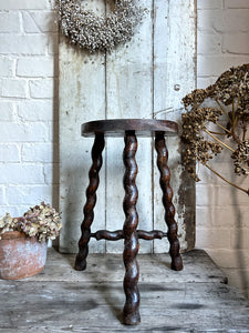 A French Vintage Demi Lune wooden tripod stool with twisted legs.