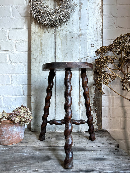 A French Vintage Demi Lune wooden tripod stool with twisted legs.