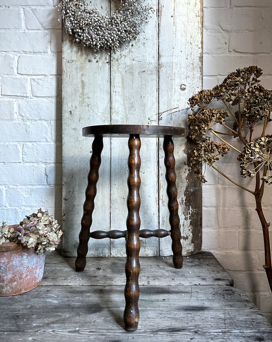 A French Vintage demi lune wooden tripod stool with bobbin legs & stretcher