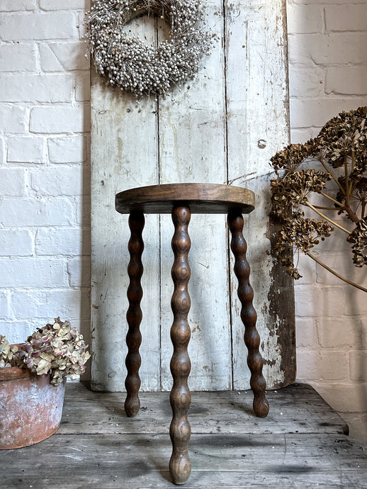 A French Vintage demi lune wooden tripod stool bobbin legs.