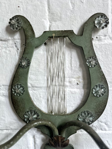 A pair of French metal lyre shaped candle wall sconces with glass flower decoration