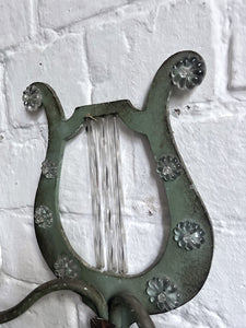 A pair of French metal lyre shaped candle wall sconces with glass flower decoration