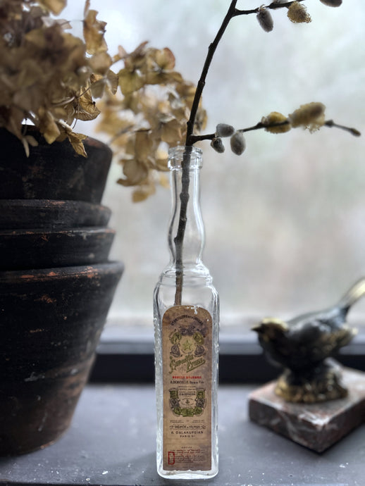 A small French vintage glass liquor bottle with original label manufactured in Paris
