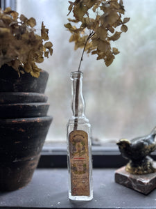 A small French vintage glass liquor bottle with original label manufactured in Paris
