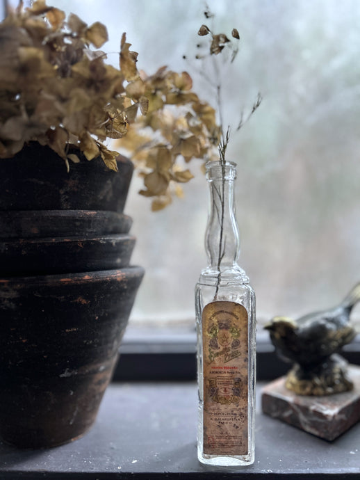 A small French vintage glass liquor bottle with original label manufactured in Paris