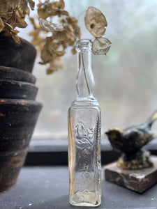 A small French vintage glass liquor bottle with original label manufactured in Paris