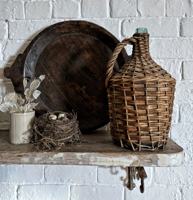 A Vintage French rustic wicker green glass wine bottle demijohn