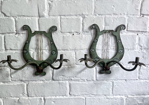 A pair of French metal lyre shaped candle wall sconces with glass flower decoration