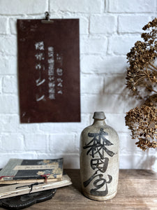 A vintage Japanese clay pottery saki bottle with calligraphy front & back