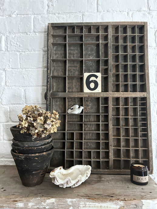 A vintage black painted wooden letter press printers drawer