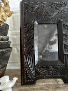 An antique arts & crafts dark wooden carved decorative photo frame