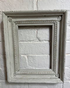 A deep sided white chippy painted decorative wooden vintage picture frame