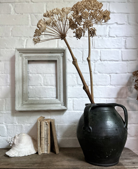 A vintage dark green unglazed terracotta Hungarian pot