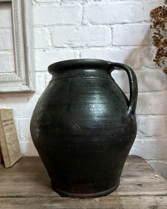 A vintage dark green unglazed terracotta Hungarian pot