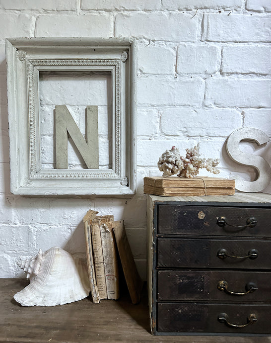 A deep sided white chippy painted decorative wooden vintage picture frame