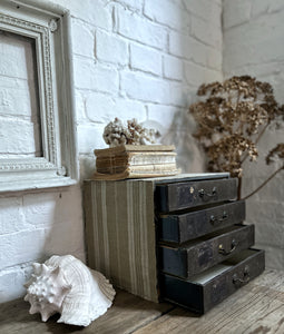 A set of vintage desk top stationary drawers covered in striped ticking fabric