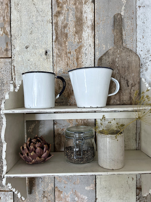 A large vintage enamel measuring jug with measurements inside