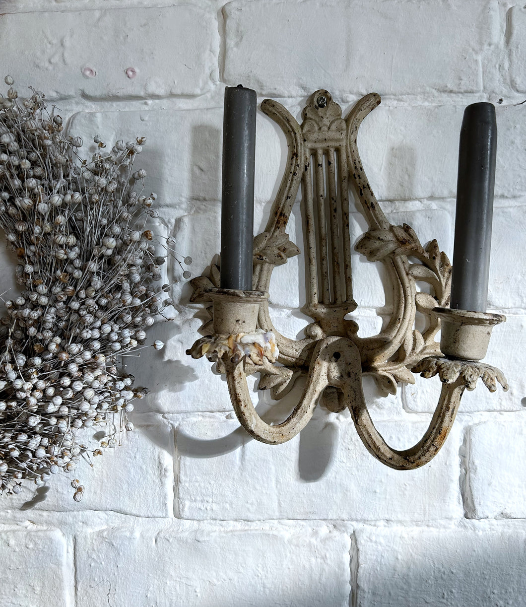 A vintage painted metal cast iron 2 arm harp lyre candle wall sconce.