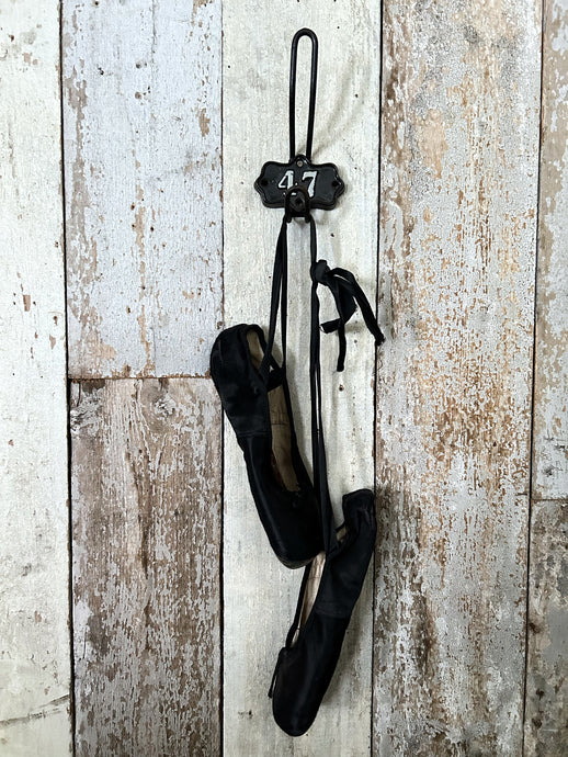 A Vintage industrial cast iron numbered shield back coat hook number 47.
