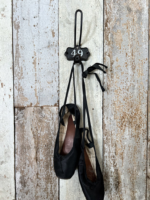 A Vintage industrial cast iron numbered shield back coat hook number 49.