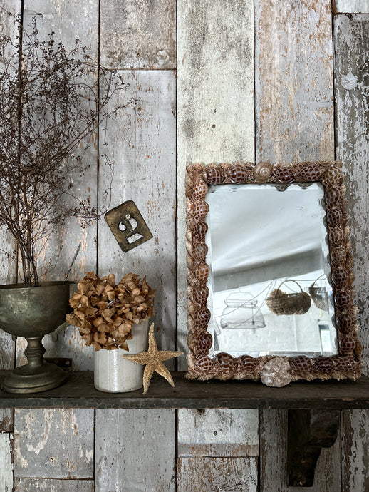 A vintage sea shell covered decorative wooden wall hanging mirror