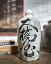 Load image into Gallery viewer, An early 20th Century antique stone Japanese Saki bottle with black calligraphy