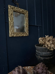 A small gold gilded decorative antique wall mirror