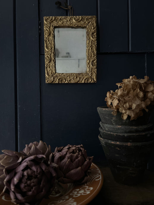 A small gold gilded decorative antique wall mirror