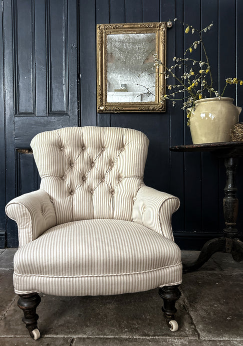 A Victorian Button back antique ticking striped arm chair