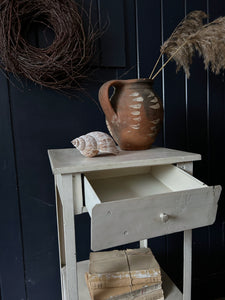 A vintage white painted metal locker style cabinet