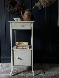 A vintage white painted metal locker style cabinet