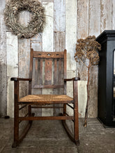 Load image into Gallery viewer, An antique wooden oak carved Arts &amp; Crafts rush seat rocking chair