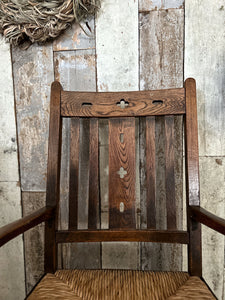 An antique wooden oak carved Arts & Crafts rush seat rocking chair