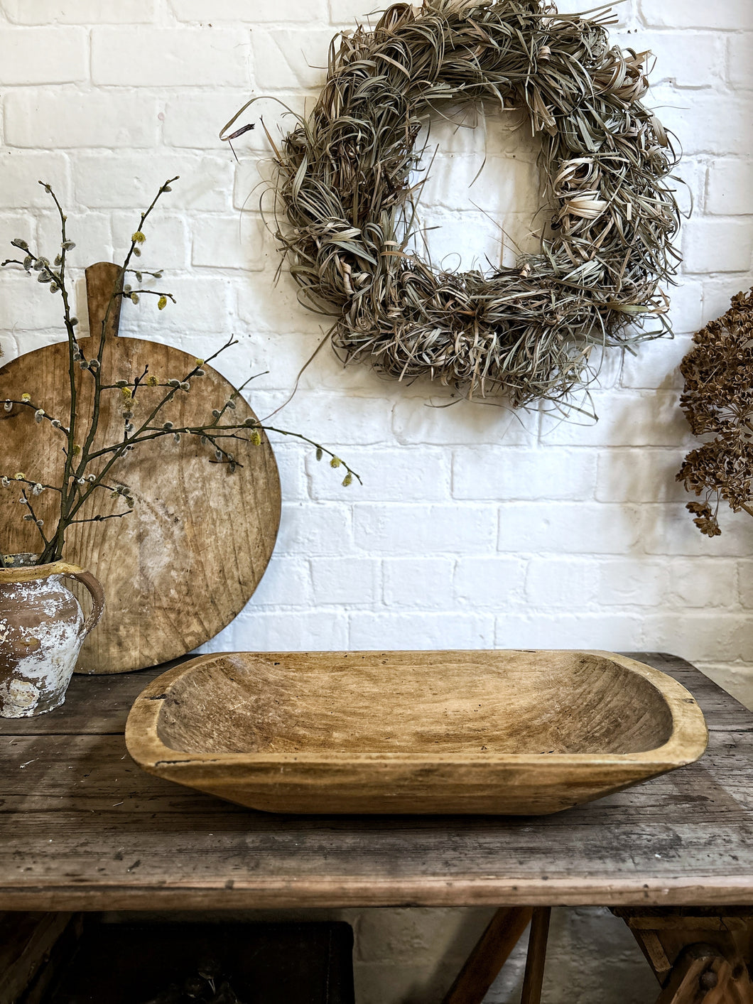 A rustic hand carved wooden antique dough bowl
