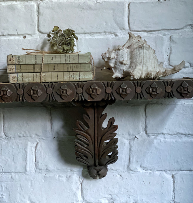 vintage display shelf. Decorative carved from dark wood with beautiful detailing along the edges and a central carved acanthus leaf.